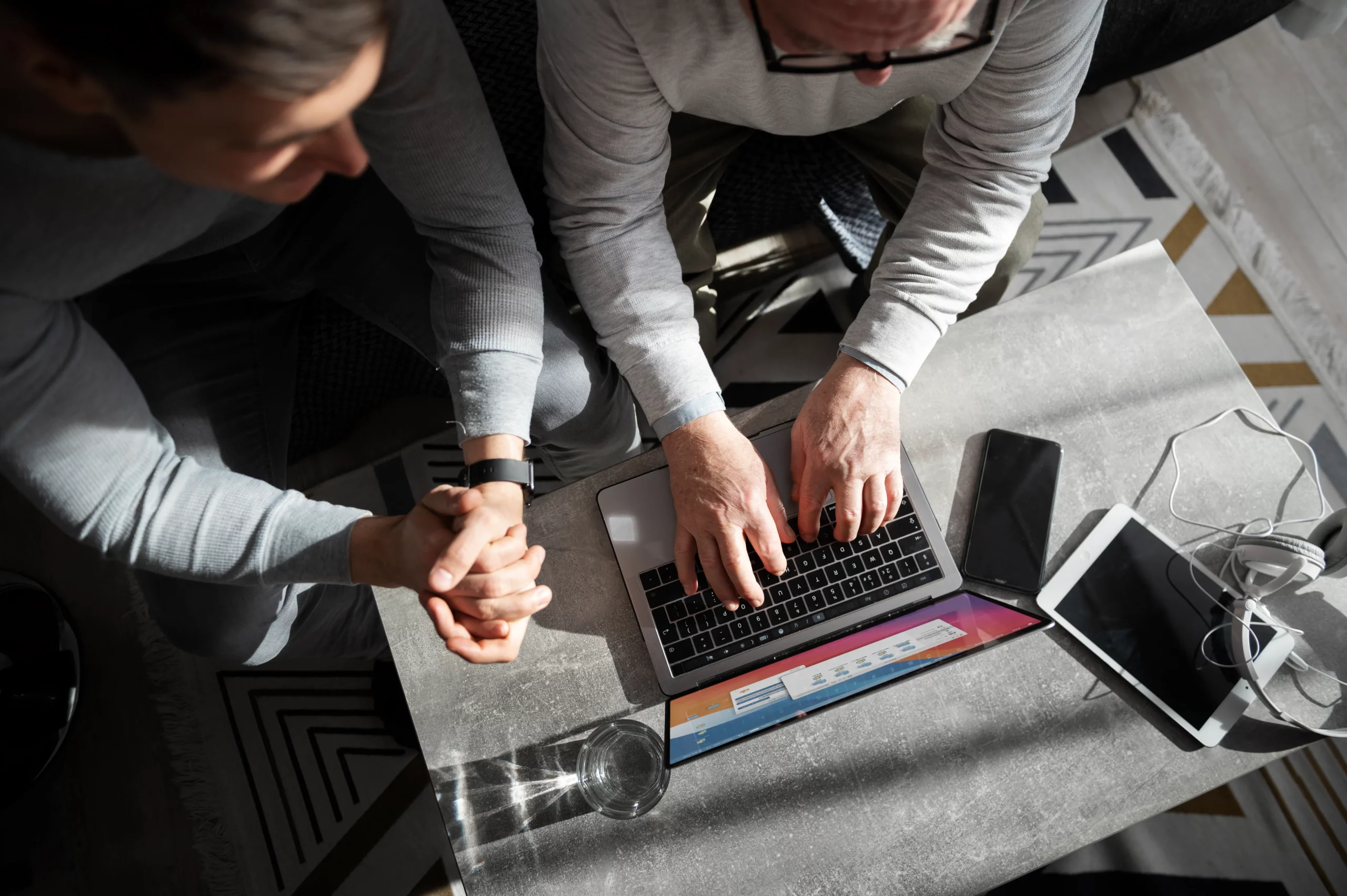 a man and woman sitting at a table working a laptop